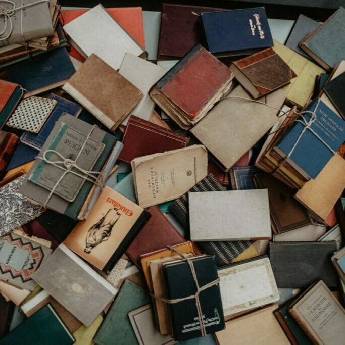 brown and white books on brown wooden table